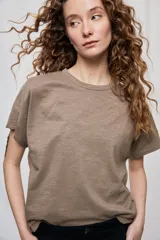 Remera negra de manga corta con cuello redondo y silueta amplia, de hombros caídos y textura suave.