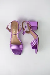 Sandalias de fiesta marca Mari, con acabado metalizado morado, taco cuadrado de 4 cm, tiras fruncidas en la parte delantera y tira ajustable al tobillo con hebilla dorada.