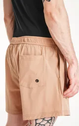 Short de baño color beige con cintura elástica y cordón ajustable. Cuenta con tres bolsillos y un parche con logo en la pierna izquierda.