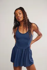 Vestido corto deportivo negro con efecto smock en el torso, tirantes finos blancos y falda de vuelo suave.