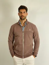 Campera de algodón con cierre frontal completo, cuello alto y bolsillos tipo canguro. Presenta puños y ruedo acanalados, con un pequeño logo bordado en el pecho.