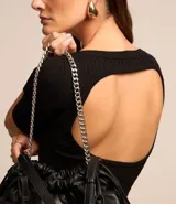 Blusa negra de viscosa con cuello redondo, mangas cortas y textura acanalada. Presenta un recorte oval en la espalda.