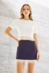 Minifalda azul marino con detalle de flecos de perlas en el ruedo.