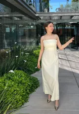 Vestido midi a rayas verticales color blanco y amarillo, con breteles finos y corte recto.