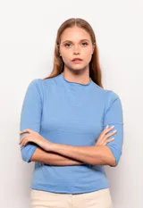 Polera manga 3/4 color lila, de corte ajustado y cuello alto con detalle de tela con textura a rayas horizontales.