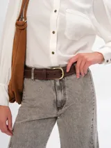 Cinturón marrón de cuero con costuras a contratono y hebilla dorada.