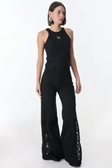 Pantalón de jean azul oscuro de pierna ancha y tiro medio, con paneles laterales en contraste de color marrón. Presenta costuras pespunteadas en tono tostado y terminación desmechada en el bajo.