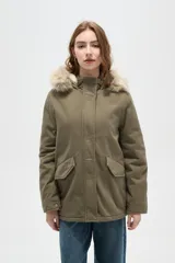 Campera parka de color verde militar, con cierre frontal oculto, bolsillos laterales con solapa y capucha fija con borde de piel sintética.