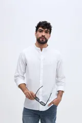 Camisa de lino y algodón color celeste, con cuello mao, cierre frontal de botones claros y pequeño bordado de pato en el pecho.