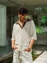 Chomba de tejido de punto abierto color crudo con cuello polo en color marrón chocolate.