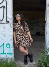 Vestido corto de fibrana con estampado animal print, corte holgado, cuello camisero y mangas cortas.