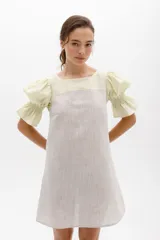 Vestido corto a rayas verticales color gris y blanco, con cuello redondo y mangas cortas abullonadas color amarillo pálido con detalle de elástico en el puño.