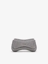 Cartera bandolera compacta Diesel Play Crossbody XS, de diseño curvo con acabado brillante plateado. Cuenta con el icónico logo Oval D en el frente y correa desmontable para llevarla cruzada o como clutch.