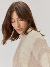 Buzo de tejido de punto con diseño de rayas verticales anchas en tonos beige y crema, cuello semipolera y manga larga.