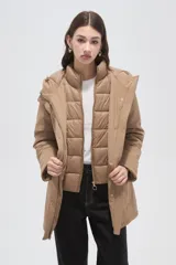 Campera 3 en 1 color beige, compuesta por una campera exterior impermeable con capucha y una campera interior capitonada con cierre frontal y cuello alto.