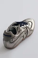 Championes deportivos color marrón con diseño de líneas onduladas en tono claro, cordones al tono y suela de goma.