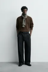 Jersey de punto de lana color marrón oscuro, de calce regular y manga larga, con cuello redondo y acabados enrollados en puños y ruedo.