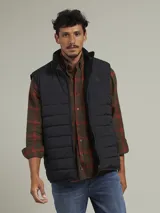 Chaleco negro acolchado con cuello alto y cierre frontal con cremallera.