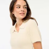 Remera de punto con textura suave, color beige, de manga corta y cuello tipo polo con escote en V.