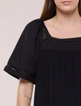 Blusa de corte holgado color marfil, confeccionada en mezcla de modal y algodón, con escote cuadrado y mangas cortas adornadas con detalles de puntilla calada.
