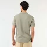 Remera de manga corta con cuello polo y escote en V, confeccionada en tejido con textura de nido de abeja.