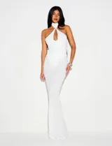 Vestido largo blanco de corte sirena y ajustado al cuerpo, con escote halter, cuello alto, abertura frontal en forma de gota y recortes laterales en la cintura.