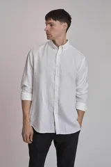Camisa blanca de lino con cuello abotonado, manga larga con puños abotonados y corte clásico.