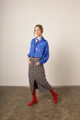 Camisa crop azul con estampado de motivos abstractos en blanco y rosa, cuello clásico y lazo en el escote.