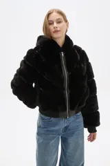 Campera bomber negra de piel sintética con capucha de piel sintética, cierre frontal con cremallera, bolsillos laterales y puños y bajo acanalados.