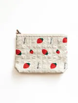 Necesser acolchado color crema con estampado de frutillas y la palabra 'Smile' en negro.