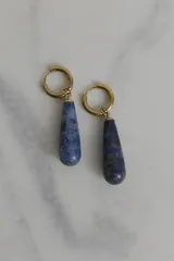 Aros tipo argolla con dije colgante en forma de gota de piedra natural en tonos marrones. Fabricados en acero quirúrgico dorado.