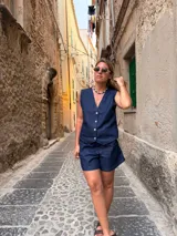 Short de jean azul oscuro con costuras contrastantes en tono tostado, de tiro medio y corte clásico.