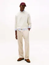 Buzo color crema de Tommy Hilfiger, de corte clásico y cuello redondo. Tiene el logo de la marca bordado en el pecho.