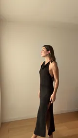 Vestido largo negro de punto con hilo brillante, diseño ajustado, escote halter y cuello drapeado.