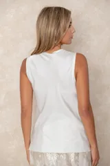 Musculosa de cuello redondo con acabado satinado y caída fluida.