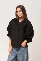 Camisa negra de poplin, corte amplio con mangas abullonadas y botones a tono.