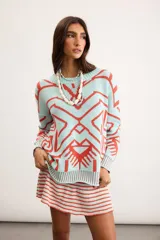 Buzo oversize de punto color marfil con diseño geométrico jacquard en tonos rosado, amarillo, celeste y marrón. Cuenta con cuello redondo y mangas largas.