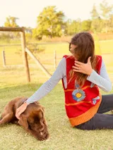 Chaleco de lana merino color rojo con flores bordadas a mano en azul y amarillo.