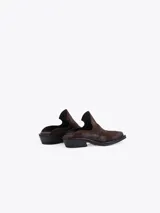 Zueco estilo western de cuero vacuno plateado, con costuras decorativas en la capellada, punta cuadrada y taco bajo de 4 cm.
