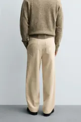Pantalón de corte regular fit confeccionado en pana de algodón color beige, con bolsillos frontales, bolsillos traseros de plastrón y cierre frontal con cremallera y botón.