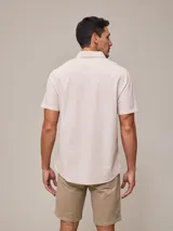 Camisa de manga corta con rayas verticales azules y blancas, confeccionada en algodón.