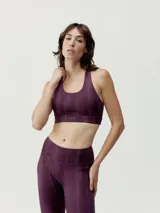 Top deportivo de sujeción media color borgoña, con tirantes finos dobles y cruzados en la espalda. Estampado con diseño exclusivo BORN. Confeccionado en tejido Shape_Tech.