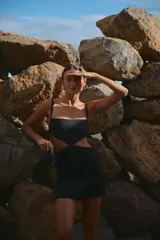 Minivestido negro de lino y rayón con escote recto, breteles regulables y espalda con tiras regulables.