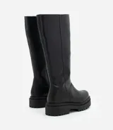 Bota de caña alta confeccionada en PU, con suela tractorada robusta y puntera redondeada. Diseño moderno y versátil con taco de 5,3 cm.