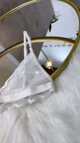Set de lencería de cuatro piezas compuesto por bralette de encaje y microtul, tanga regulable, portaligas y ligas. Diseño con transparencias y detalles de encaje.