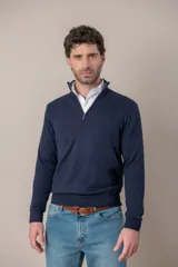 Sweater de punto color azul marino, con cuello alto y cierre frontal parcial. Presenta puños y ruedo acanalados.