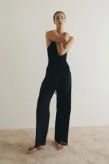 Pantalón de corte holgado en popelina de algodón, color negro, con cintura elástica y cordón de ajuste. Presenta piernas rectas, franjas de encaje en los laterales y ribete de encaje en los bajos.