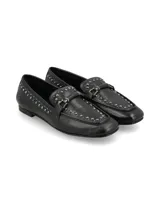 Mocasín de cuero negro con tachas metálicas decorativas a lo largo del borde y en la lengüeta, con tira frontal y hebilla metálica.