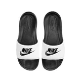 Chancletas Nike modelo Victori One Slide, con base negra y tira ancha superior blanca que presenta el logotipo y la palabra Nike estampados en negro.