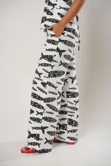 Pantalón palazzo blanco con estampado de peces negros.